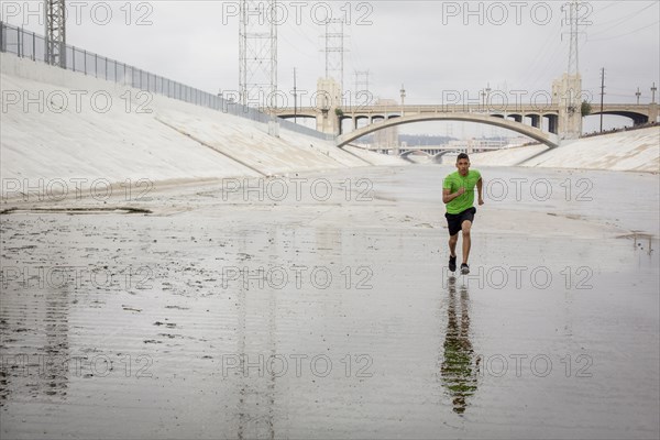 Mixed Race man running in canal