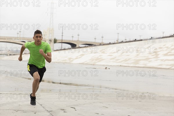 Mixed Race man running in canal