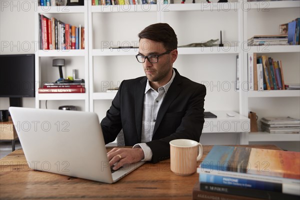 Caucasian businessman using laptop in home office