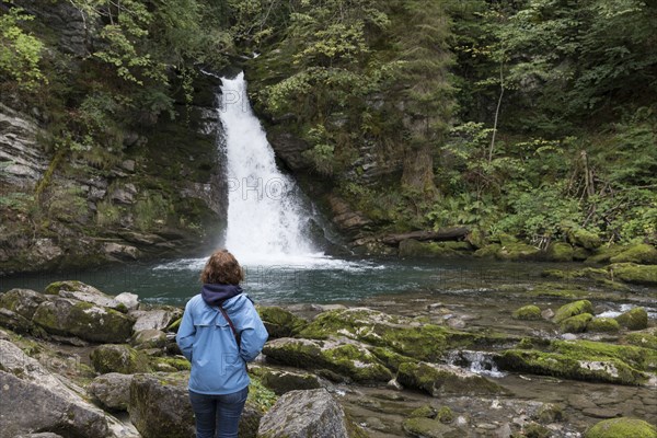 Caucasian woman admiring distant waterfall