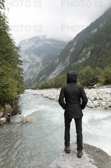 Person standing on rock near river