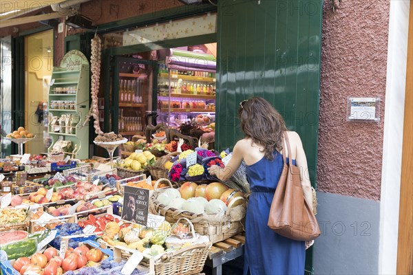 Caucasian woman shopping for fruit at sidewalk market