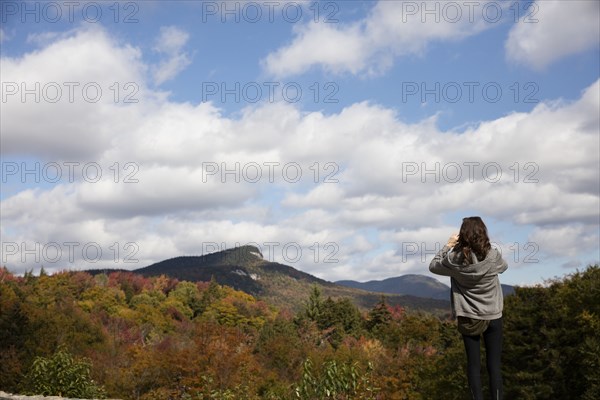 Caucasian woman admiring mountain range in autumn