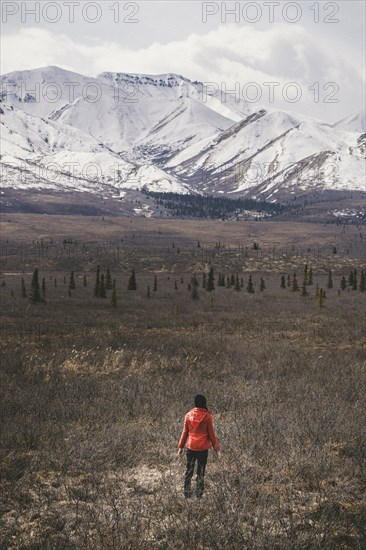 Caucasian woman standing in field near snowy mountain