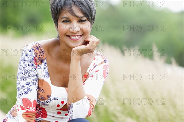 Smiling mixed race woman in field