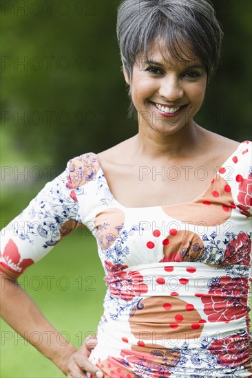 Smiling mixed race woman with hands on hips