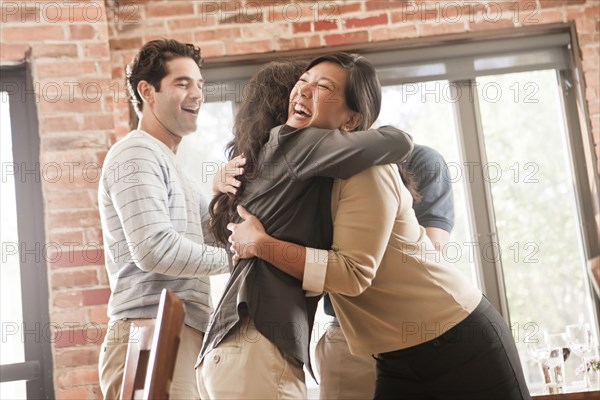 Laughing friends hugging