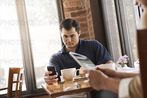Chinese man using cell phone in cafe
