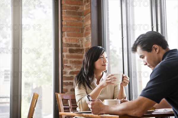 Chinese couple drinking coffee in cafe