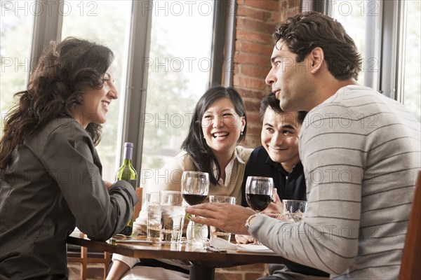 Friends drinking red wine together in restaurant