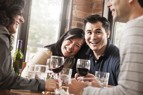 Friends drinking red wine together in restaurant