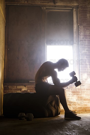 Caucasian man exercising with dumbbells