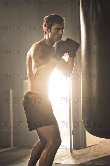 Caucasian boxer hitting punching bag