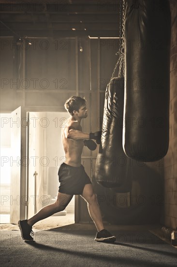 Caucasian boxer hitting punching bag
