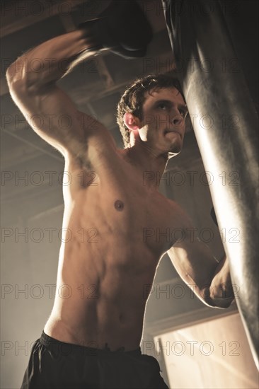 Caucasian boxer hitting punching bag