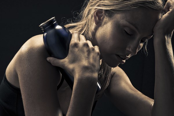 Fatigued Caucasian woman holding water bottle