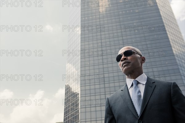 Black businessman standing near highrise