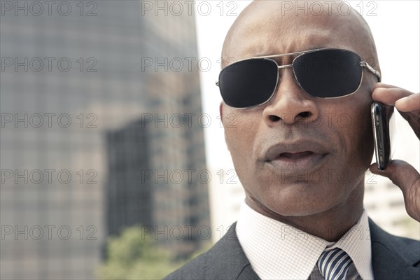 Black businessman talking on cell phone outdoors