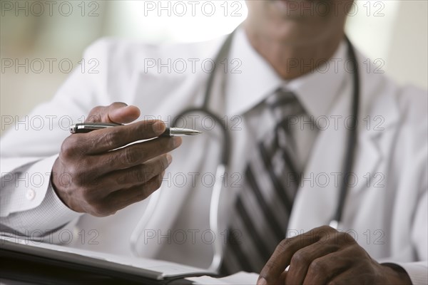 African American doctor writing in medical record