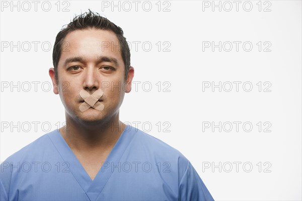 Mixed race doctor with bandages over his mouth