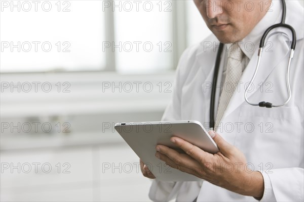 Mixed race doctor using digital tablet