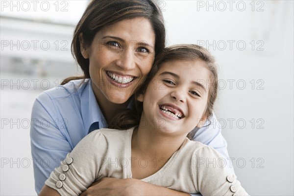 Smiling mother and daughter hugging