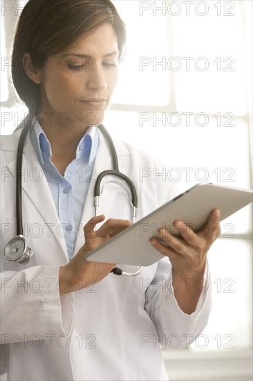 Hispanic doctor using digital tablet