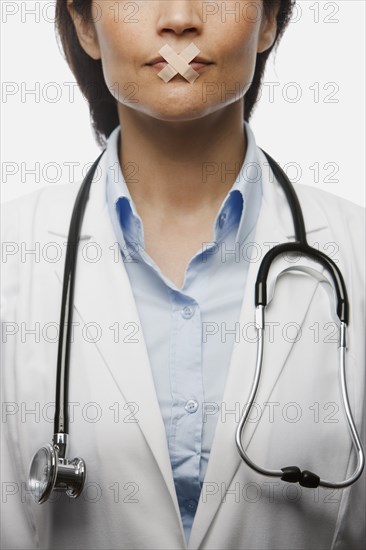 Hispanic doctor with bandages on mouth