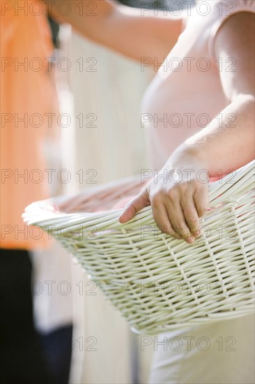 Caucasian woman holding basket and hanging laundry