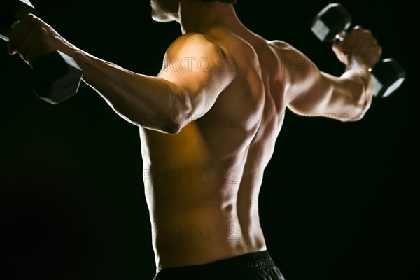 Caucasian man exercising with dumbbells