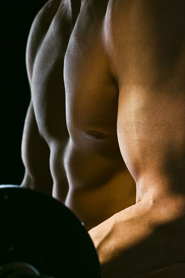 Caucasian man exercising with barbells