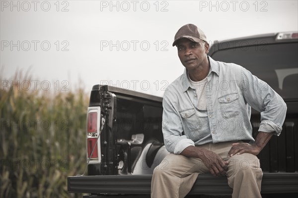 African American sitting on back of pick-up truck