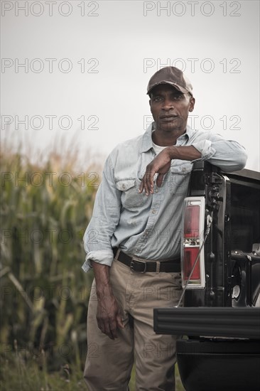 African American leaning on back of pick-up truck