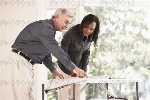 Man and woman looking at blueprints together