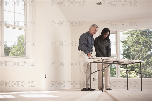 Man and woman looking at blueprints together
