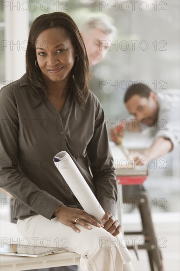 Black woman holding blueprints