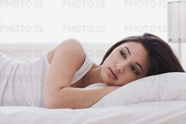 Alluring mixed race woman laying in bed