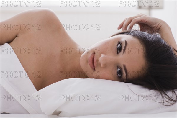 Alluring mixed race woman laying in bed