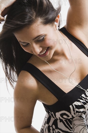Mixed race woman listening to headphones and dancing
