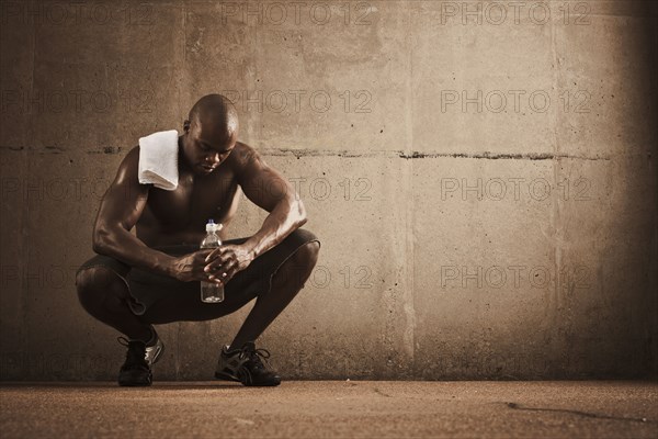 African American man drinking water after exercise