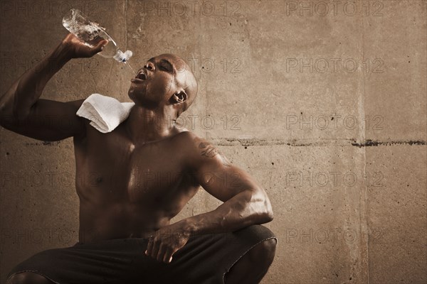 African American man drinking water after exercise