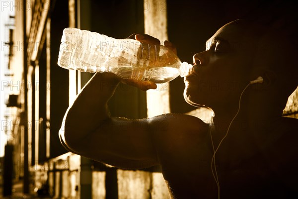 African American man drinking water after exercise