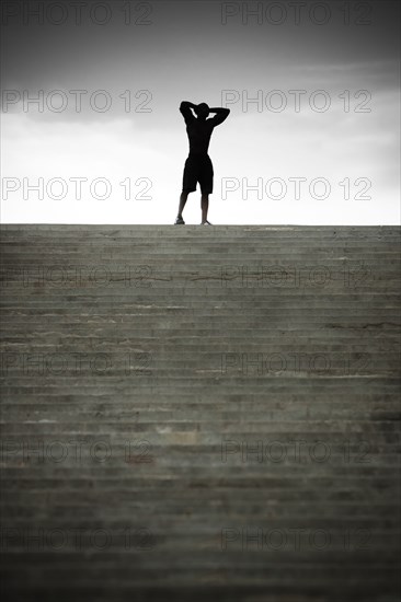 Black man stopping at top of stairs