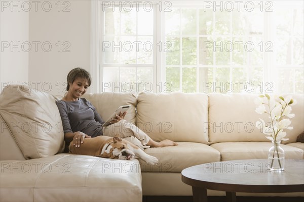 Native American woman relaxing on sofa with English bulldog