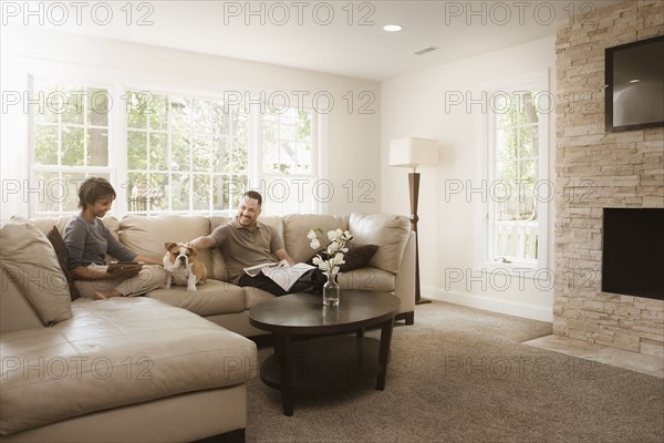 Couple sitting on sofa with English bulldog