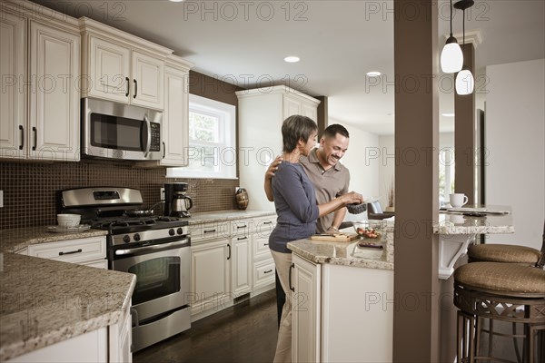 Couple preparing meal together in kitchen