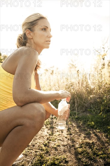 Caucasian woman drinking water after exercise