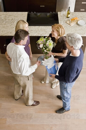 Caucasian couple giving hosts gift and flowers