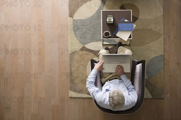 Caucasian man using laptop in living room