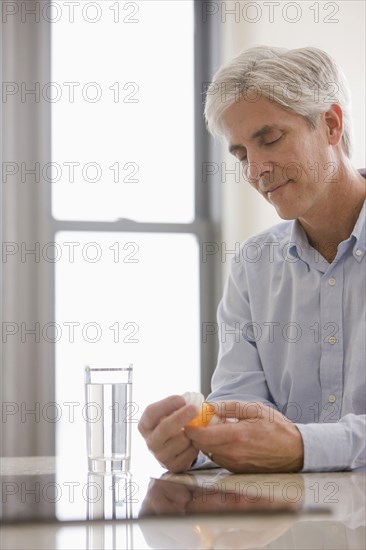 Caucasian man taking medicine